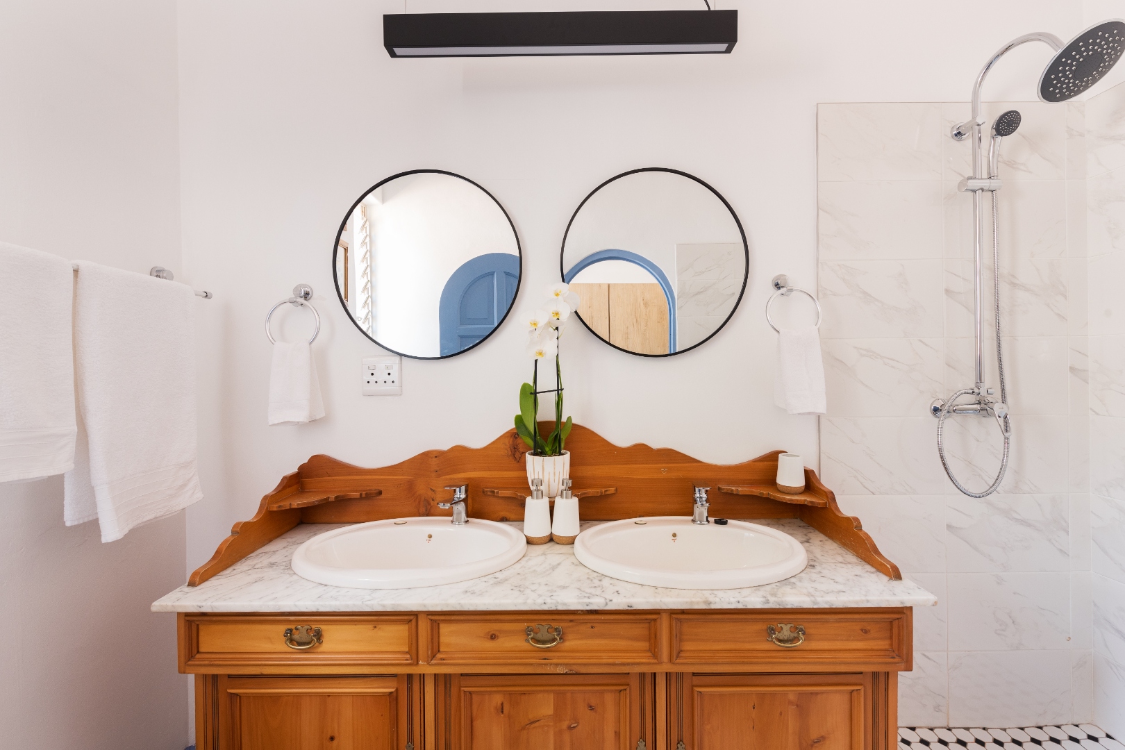 Marble en-suite bathroom with round mirrors